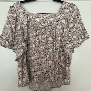 A cute flowy flower summer shirt that has muted tones